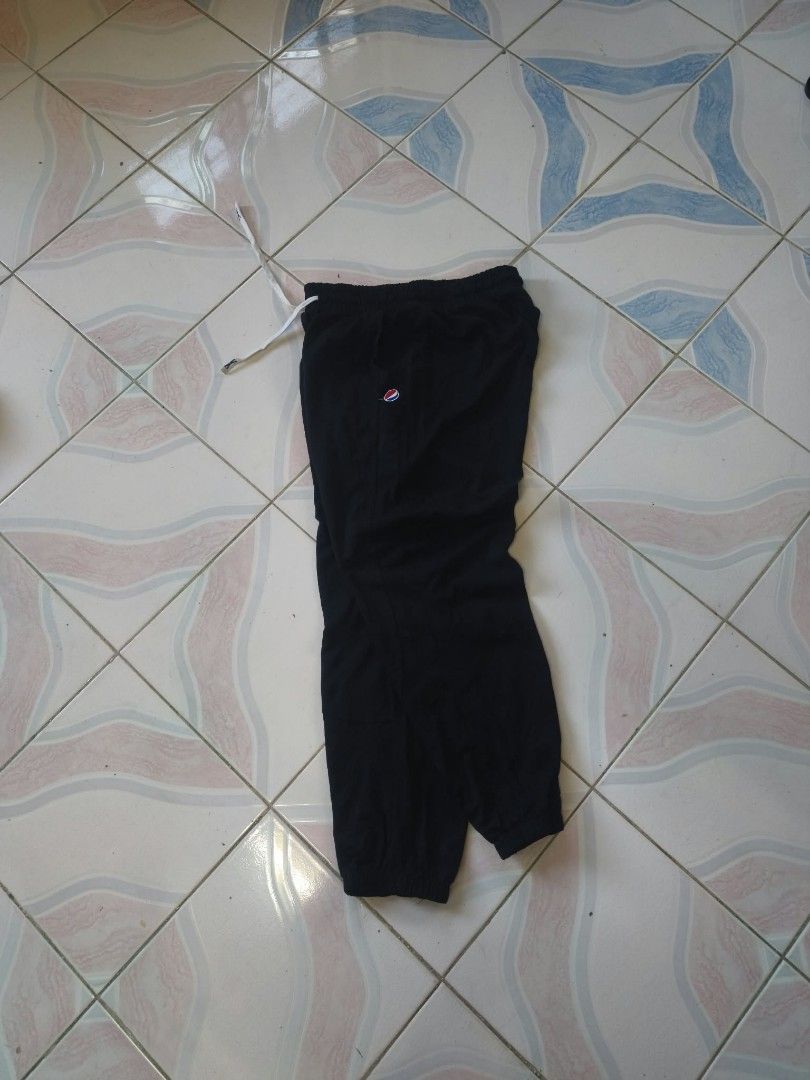 Pepsi Black Jogger Sweatpants (Category: Joggers) located in Manila. Submitted by cookthrift (Listing ID 1469573844, Image 2). Description: - Color: Black - Size: XL - Fit: Relaxed fit with cuffed ankles - Waistband: Elastic with adjustable white drawstring - Branding: Small embroidered Pepsi globe logo on the left thigh and 'pepsi' lettering near the right ankle - Condition: Brand new with official branded tag attached size 29-36 lnegth 37 excel