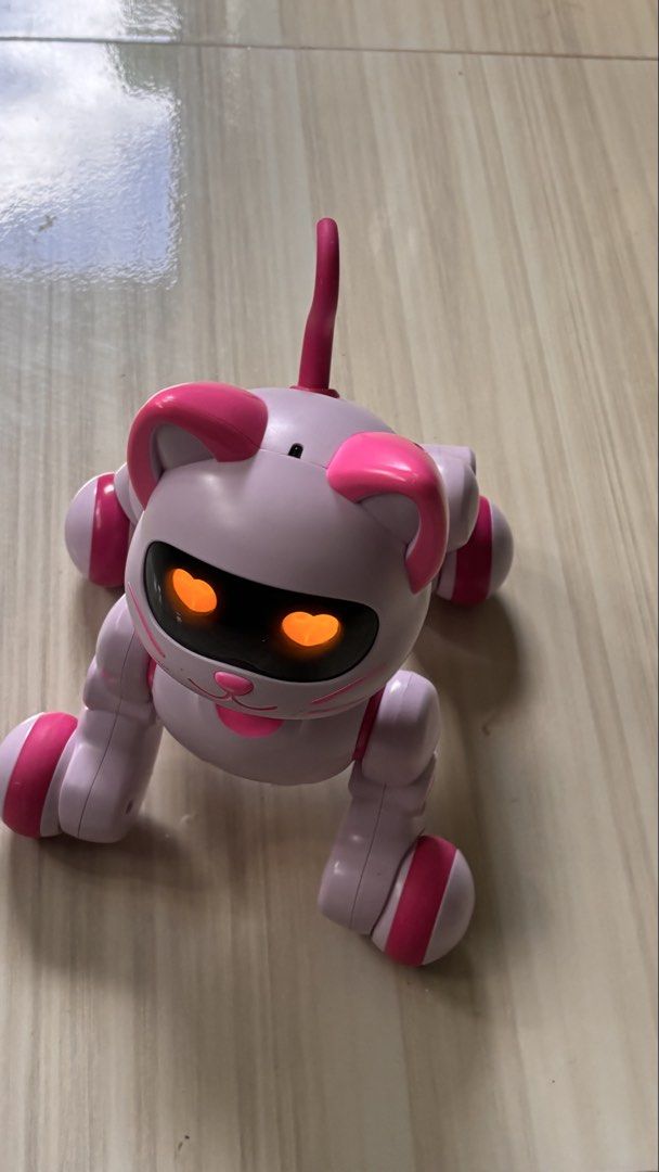 Pink Electronic Robot Cat Toy with Heart Eyes (Category: Interactive Toys) located in La Trinidad. Submitted by caicai1926 (Listing ID 1469619084, Image 1). Description: - Adorable interactive robotic cat toy in pastel purple and bright pink - Features glowing heart-shaped eyes and an upright tail - Movable legs and stands on four fun wheels - Reacts and lights up for endless play - Tested and 100% working great.