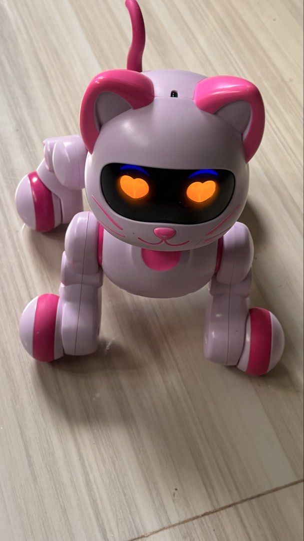 Pink Electronic Robot Cat Toy with Heart Eyes (Category: Interactive Toys) located in La Trinidad. Submitted by caicai1926 (Listing ID 1469619084, Image 3). Description: - Adorable interactive robotic cat toy in pastel purple and bright pink - Features glowing heart-shaped eyes and an upright tail - Movable legs and stands on four fun wheels - Reacts and lights up for endless play - Tested and 100% working great.