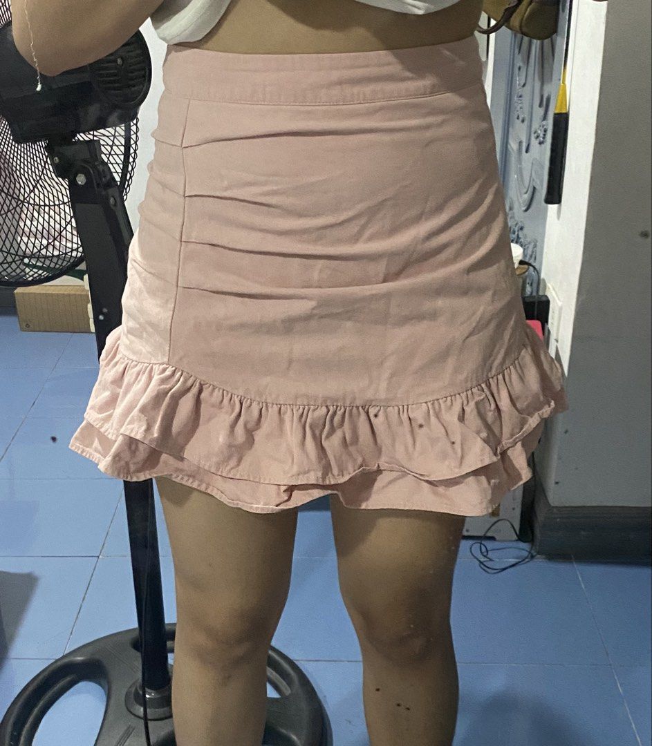 Pink Ruffle Mini Skirt (Category: Skirts) located in Bulacan. Submitted by nonu_sells (Listing ID 1469672606, Image 2). Description: - Color: Light pink - Style: High-waisted mini skirt with front ruched detailing - Design: Playful ruffle hem for added flair - Versatility: Pairs easily with casual tees or blouses, perfect for various outings - Condition: Brand new / Excellent.