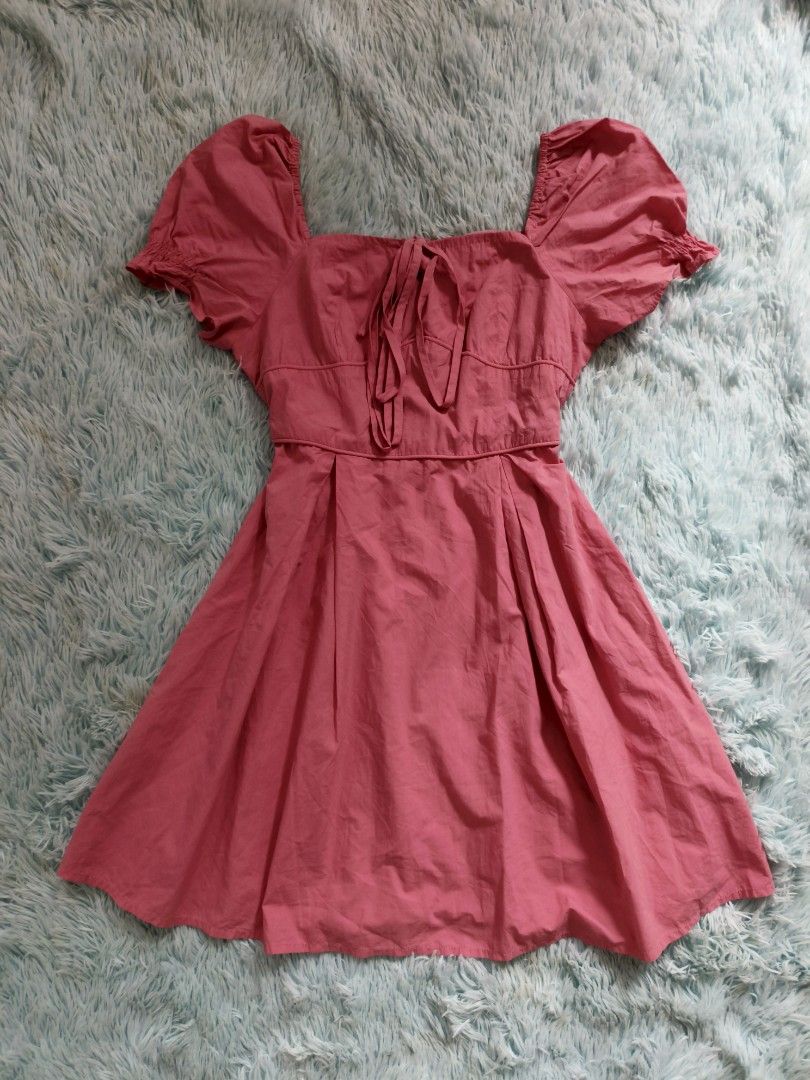 Pink square neck puff sleeve flared mini dress (Category: Dresses) located in Quezon City. Submitted by alluring.avenue (Listing ID 1469599437, Image 1). Description: - Color: Bright pink - Style: Mini dress with a fitted waist and flared pleated skirt - Sleeves: Short puff sleeves - Neckline: Square neckline with front tie-string detail - Fit: Pullover style, lightweight fabric - Perfect for: Casual days out, dates, or weekend bonding - Conditio