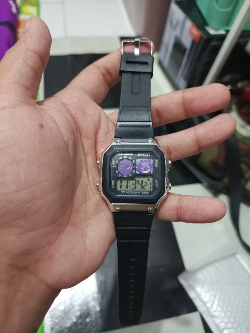 Pokemon Gengar Digital Sport Watch (Category: Men's Watches) located in Manila. Submitted by warmcrystal_269010 (Listing ID 1469702034, Image 2). Description: - Design: Cool Pokémon Gengar graphics on the watch face - Case & Strap: Sleek silver square case with a durable black rubber strap - Features: Built-in countdown timer and multiple alarms - Backlight: Vibrant pink backlight in great working condition - Condition: Excellent, fun accessory f