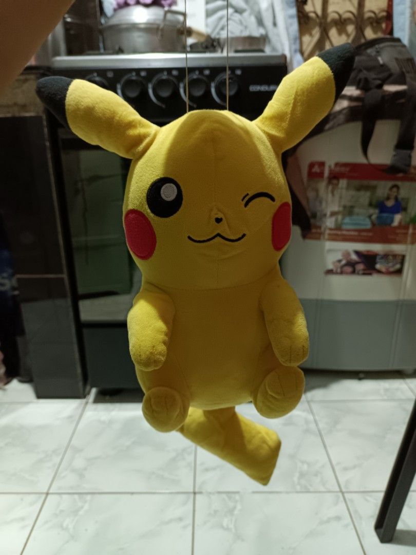 Pokemon Pikachu Plush Toy Winking Face (Category: Plushies & Soft Toys) located in Manila. Submitted by caaths_collection (Listing ID 1469705024, Image 1). Description: - Adorable yellow Pikachu plush doll with a playful winking expression - Features iconic details: red cheeks, black ear tips, back stripes, and lightning bolt tail - Made with ultra-soft, huggable fabric in a charming sitting posture - Standard size, clean and well-maintained - Gr