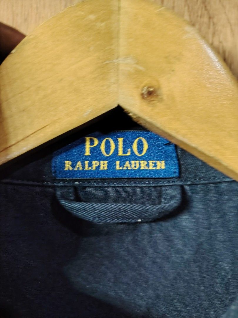Polo Ralph Lauren Navy Cotton Jacket (Category: Coats, Jackets and Outerwear) located in Baguio. Submitted by tabuzomaria1422 (Listing ID 1469701705, Image 3). Description: - Brand: Polo Ralph Lauren - Color: Dark Blue - Material: 100% Cotton (Made in China) - Design: Full zip front, side pockets, elasticized hem, and button cuffs - Details: White embroidered Polo logo on left chest, large 'POLO' print on right sleeve, and stylish striped pattern