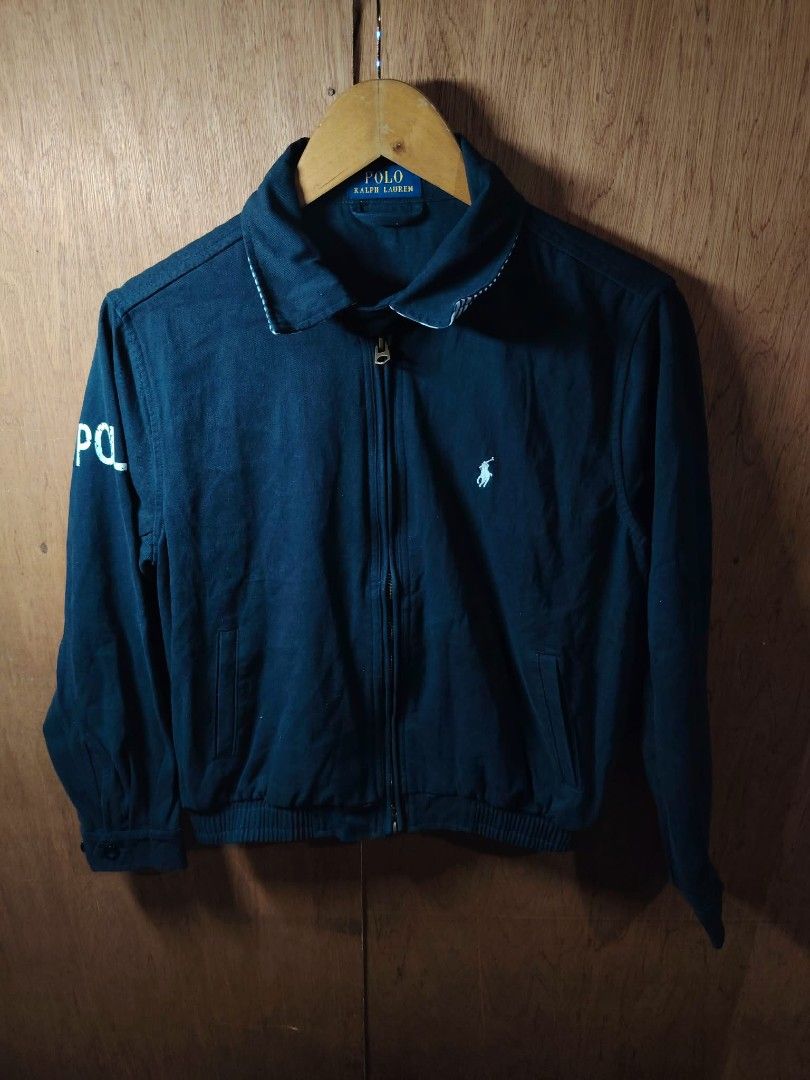 Polo Ralph Lauren Navy Cotton Jacket (Category: Coats, Jackets and Outerwear) located in Baguio. Submitted by tabuzomaria1422 (Listing ID 1469701705, Image 1). Description: - Brand: Polo Ralph Lauren - Color: Dark Blue - Material: 100% Cotton (Made in China) - Design: Full zip front, side pockets, elasticized hem, and button cuffs - Details: White embroidered Polo logo on left chest, large 'POLO' print on right sleeve, and stylish striped pattern