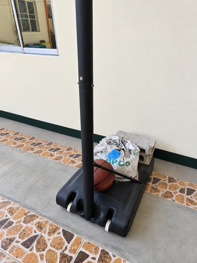 Portable Basketball Hoop System with Chain Net (Category: Racket and Ball Sports) located in Paranaque City. Submitted by cyinquimb (Listing ID 1469649854, Image 3). Description: - Portable outdoor basketball hoop setup ideal for driveways and backyards - Heavy fillable base keeps the stand stable during intense play - Sturdy black pole and rectangular backboard with vibrant yellow panels - Fitted with a heavy-duty metal chain net for longevity -