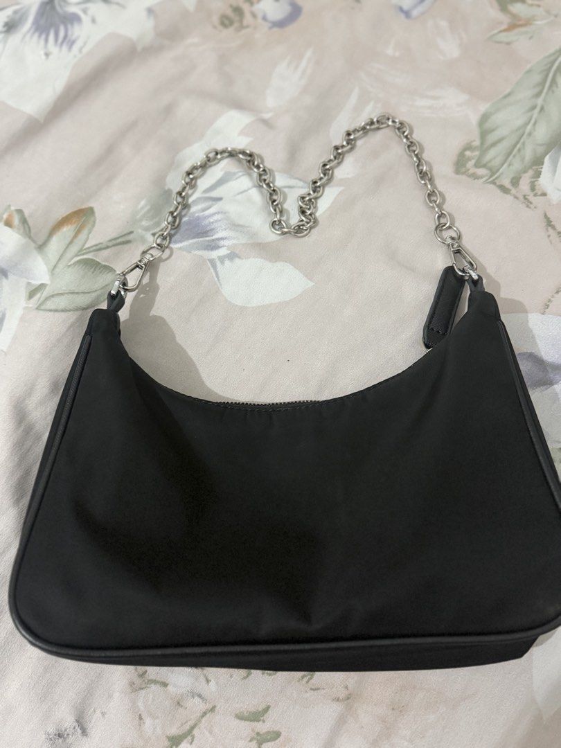 Prada Black Nylon Chain Shoulder Bag (Category: Luxury Bags & Wallets) located in Manila. Submitted by maambeeeeyah (Listing ID 1469661532, Image 3). Description: - Brand: Prada - Material: Durable black nylon - Hardware: Silver chain strap and metal logo plaque - Logo: Iconic metal triangle logo on front - Closure: Secure top zip - Interior: Prada monogram lining - Condition: Clean overall shape - Size: Compact and convenient for daily essential
