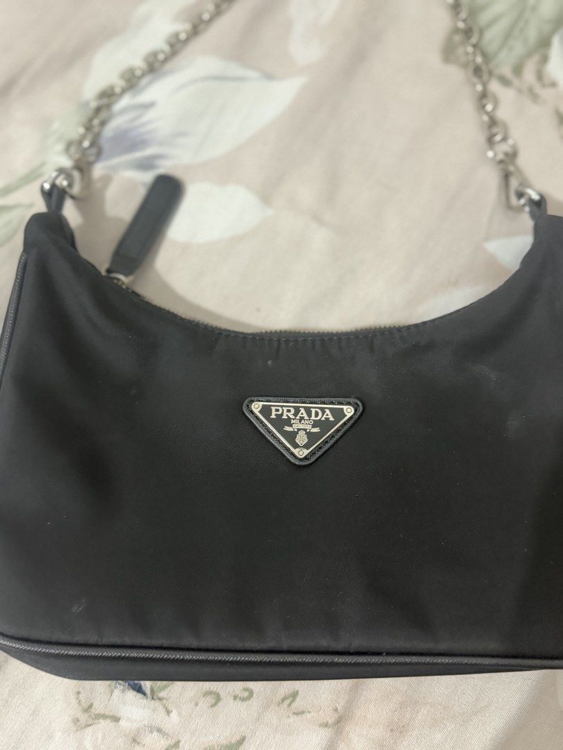 Prada Black Nylon Chain Shoulder Bag (Category: Luxury Bags & Wallets) located in Manila. Submitted by maambeeeeyah (Listing ID 1469661532, Image 2). Description: - Brand: Prada - Material: Durable black nylon - Hardware: Silver chain strap and metal logo plaque - Logo: Iconic metal triangle logo on front - Closure: Secure top zip - Interior: Prada monogram lining - Condition: Clean overall shape - Size: Compact and convenient for daily essential