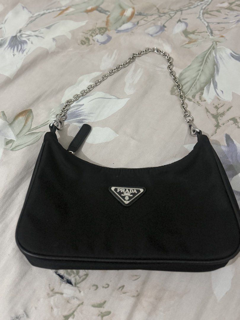 Prada Black Nylon Chain Shoulder Bag (Category: Luxury Bags & Wallets) located in Manila. Submitted by maambeeeeyah (Listing ID 1469661532, Image 1). Description: - Brand: Prada - Material: Durable black nylon - Hardware: Silver chain strap and metal logo plaque - Logo: Iconic metal triangle logo on front - Closure: Secure top zip - Interior: Prada monogram lining - Condition: Clean overall shape - Size: Compact and convenient for daily essential