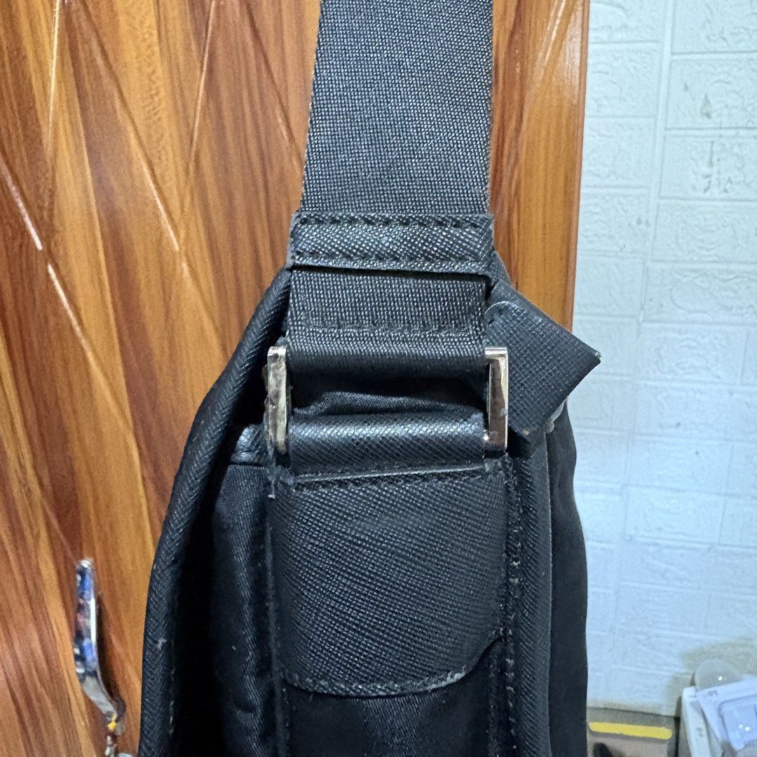 Prada Black Nylon Messenger Bag (Category: Luxury Bags & Wallets) located in Carmen. Submitted by rr_thrifts (Listing ID 1469686798, Image 2). Description: - Prada black nylon messenger bag - Front flap closure with buckle details and embossed logo - Iconic enamel triangle logo plaque on the side - Adjustable shoulder strap for comfortable wear - Condition: Some wear and fraying along the edge piping near the bottom corner (please check photos) -