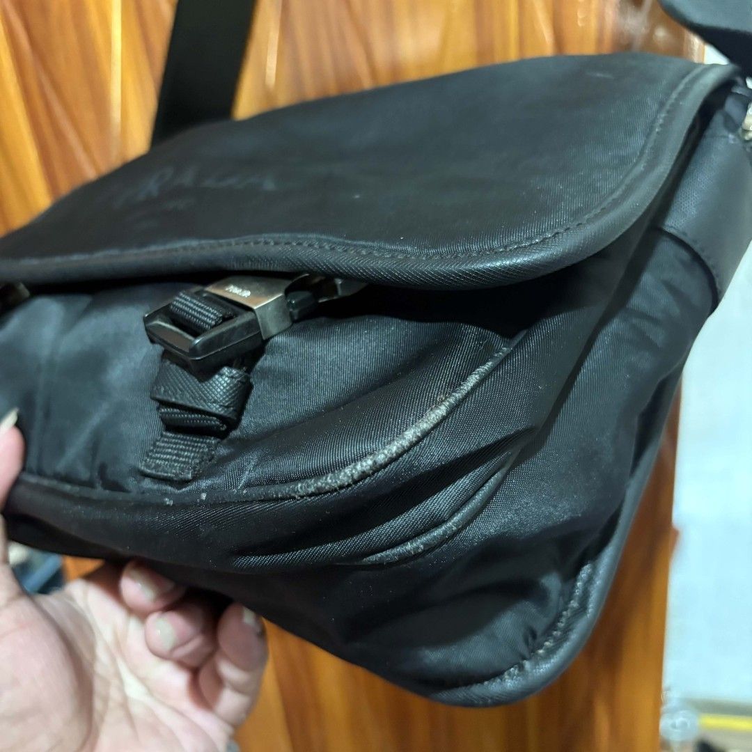 Prada Milano Black Nylon Messenger Bag (Category: Luxury Bags & Wallets) located in Carmen. Submitted by ar_thrift00 (Listing ID 1469634356, Image 2). Description: - Black Prada Milano messenger bag - Made from durable, classic black nylon - Iconic Prada triangle logo badge on the side strap base - Secure dual buckle front flap closure with adjustable strap - Sleek silver-tone hardware and zippers - Interior lined with signature jacquard fabric a