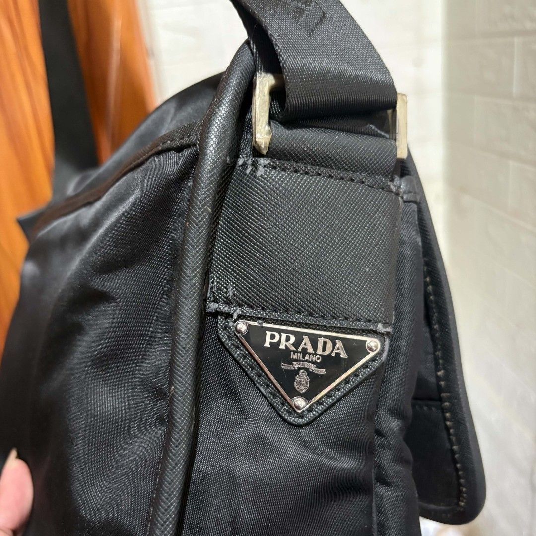 Prada Milano Black Nylon Messenger Bag (Category: Luxury Bags & Wallets) located in Carmen. Submitted by ar_thrift00 (Listing ID 1469634356, Image 3). Description: - Black Prada Milano messenger bag - Made from durable, classic black nylon - Iconic Prada triangle logo badge on the side strap base - Secure dual buckle front flap closure with adjustable strap - Sleek silver-tone hardware and zippers - Interior lined with signature jacquard fabric a