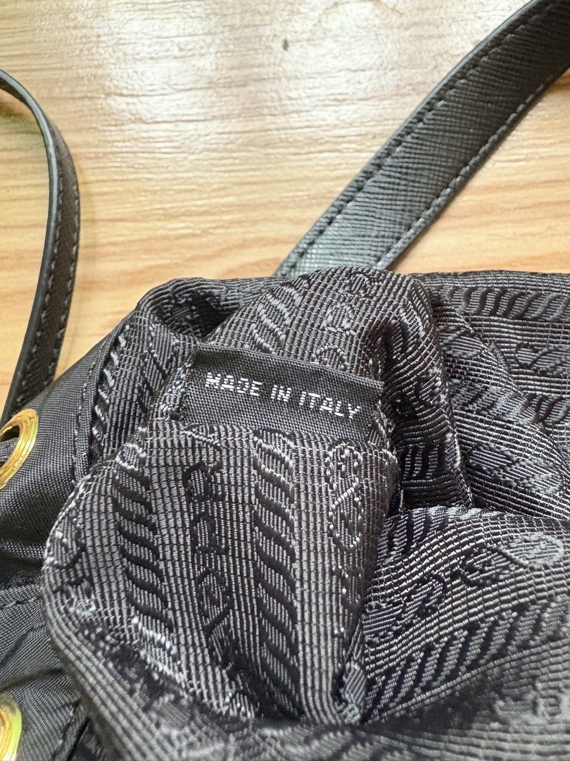 Prada Nylon Bucket Bag (Category: Luxury Bags & Wallets) located in Manila. Submitted by bravestone14 (Listing ID 1469688787, Image 3). Description: Prada nylon bucket bag (Authentic) featuring a drawstring top, gold-tone hardware, and an enameled triangular Prada logo plaque on a front exterior pocket No issue Good as new condition 10k+sf HEARING OFFERS✨ 📩 .