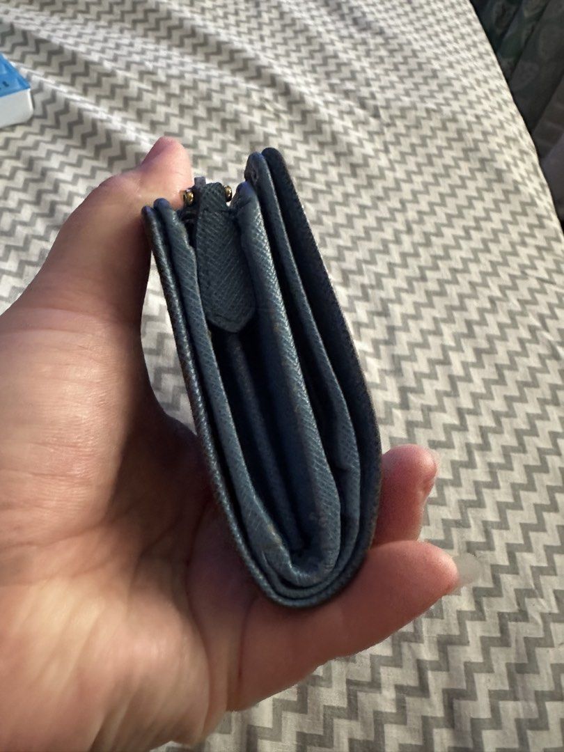 Prada Saffiano Blue Leather Wallet (Category: Luxury Bags & Wallets) located in Antipolo. Submitted by prelovedcloseta (Listing ID 1469608186, Image 3). Description: - Authentic blue Prada Saffiano leather wallet - Elegant gold hardware logo on the front - Secure snap closure strap - Multiple card slots and spacious cash sections - Convenient zippered side pocket for coins - Compact size fits easily into any everyday bag.