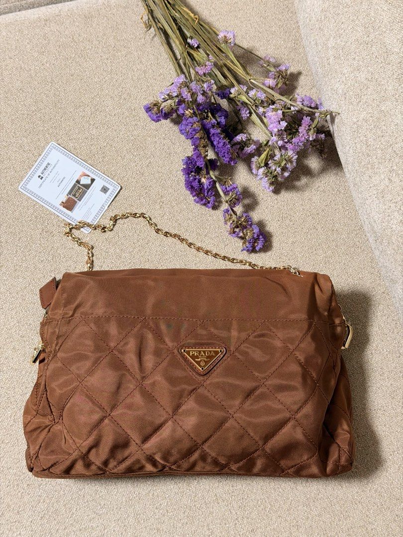 Prada Vintage Diamond Quilted Nylon Pouch with Chain (Category: Luxury Bags & Wallets) located in Manila. Submitted by monicagellerbing__ (Listing ID 1469706128, Image 2). Description: - Authentic vintage Prada diamond quilted nylon pouch in classic brown - Elegant gold-tone chain strap and matching hardware - Features the signature triangular Prada metal logo plaque on the front - Verified authentic with an included certificate of authenticity f