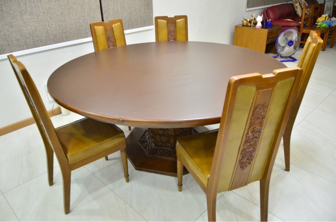 Preloved Narra Dining Set 12 Pax (Category: Tables & Sets) located in Quezon City. Submitted by docangela (Listing ID 1469620600, Image 1). Description: - Set includes: 1 large round wooden dining table and 10 matching chairs - Table features a rich brown finish and a sturdy pedestal base - Chairs feature eye-catching mustard-yellow upholstered panels - Backrests adorned with intricate floral and fruit wood carvings - Standard dining height with 