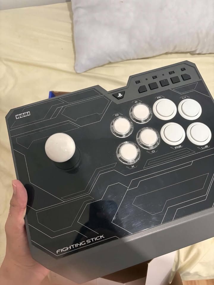 PS4 Hori Fighting Stick For (PS4-129A) (Category: Controllers) located in Binan City. Submitted by safe_gorpfriday (Listing ID 1469721496, Image 1). Description: Hori Fighting Stick with Receipt NEGOTIABLE!!! - Comes complete with the original box - Standard arcade layout featuring a responsive joystick and eight action buttons - Stylish black finish with grey accents and a clean white ball top - Tested and working great, ready to use Issue: Sunk