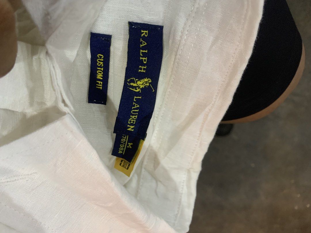 Ralph Lauren Custom Fit White Button-Down Shirt Size M (Category: Luxury Apparel) located in Cagayan de Oro. Submitted by agboysalis60090 (Listing ID 1469711896, Image 2). Description: White button-down shirt from Ralph Lauren, custom fit, size medium (170/98A). Classic long sleeve style with button cuffs and collar. Navy blue polo player embroidered on the chest. Tag includes QR code and brand details. Care label shows wash instructions for colo