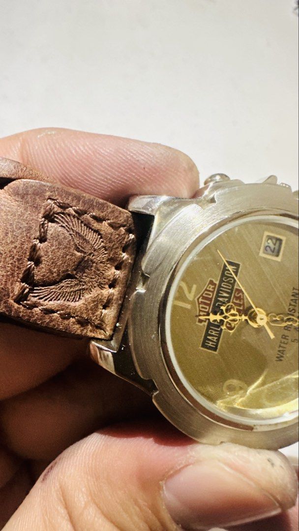 Rare Vintage Harley-Davidson all OG (Category: Men's Watches) located in Candelaria. Submitted by kabjtc (Listing ID 1469258063, Image 3). Description: Up for sale is a rare, vintage Harley-Davidson Motor Cycles analog watch featuring a distinct rugged aesthetic. This timepiece showcases a classic gold-tone dial stamped with the iconic Harley-Davidson Bar & Shield logo, complete with a date window display at the 3 o’clock position. The standout f