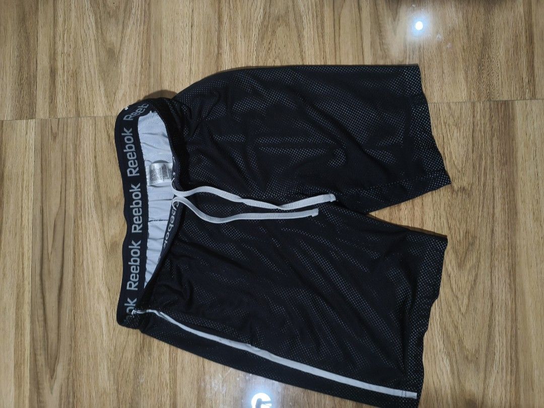 Reebok Black Mesh Athletic Shorts with Drawstring (Category: Shorts) located in Munoz. Submitted by toy_zone (Listing ID 1469672816, Image 1). Description: - Brand: Reebok - Color: Black - Material: Breathable athletic mesh fabric - Waistband: Elastic with all-over Reebok branding - Features: Adjustable white drawstring and stylish side stripe detail - Best for: Gym workouts, running, sports, or everyday lounging - Condition: Excellent / Well-mai