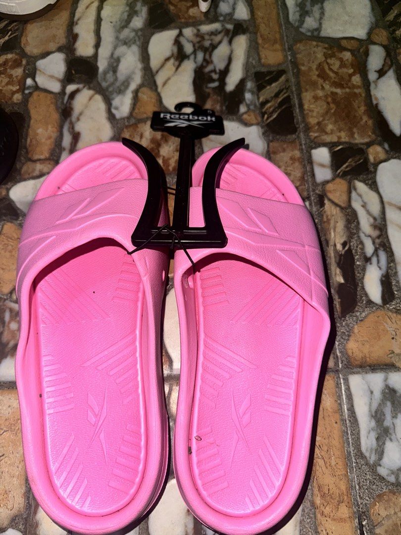 Reebok Pink Slides Sandals (Category: Slippers and slides) located in Bugallon. Submitted by lavenderlane (Listing ID 1469676224, Image 1). Description: - Brand new bright pink Reebok slides with original plastic hanger tag attached - Comfortable slip-on design perfect for daily wear - Features a textured footbed and durable outsole for added comfort and grip - Size details conveniently printed on the inner strap - Grab them while they are availa