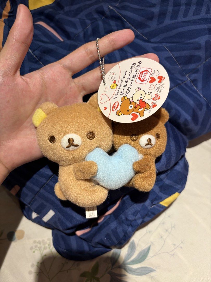Rilakkuma Pair Heart Plush Keychain (Category: Plushies & Soft Toys) located in Makati City. Submitted by squishycorner (Listing ID 1469714359, Image 1). Description: - Item: Official San-X Rilakkuma & Korilakkuma plush keychain - Design: The pair is holding a cute light blue heart together - Condition: Brand new, clean, fluffy, and stored away from dust - Inclusions: Original tag still attached and silver ball chain included - Perfect for bag ch