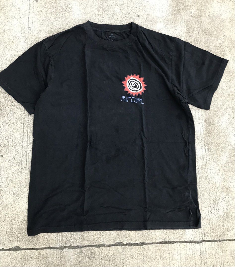 Rip Curl Black Graphic T-Shirt (Category: Tshirts & Polo Shirts ) located in Roxas City. Submitted by rarebear_71a51d (Listing ID 1469704267, Image 1). Description: - Brand: Rip Curl - Color: Classic Black - Design: Small red sun chest graphic, large tribal triangle back print with branding - Fit: Relaxed, comfortable fit - Material: 100% soft cotton - Condition: Excellent / Good as new - Style: Casual, streetwear, everyday wear - Mode of Payment