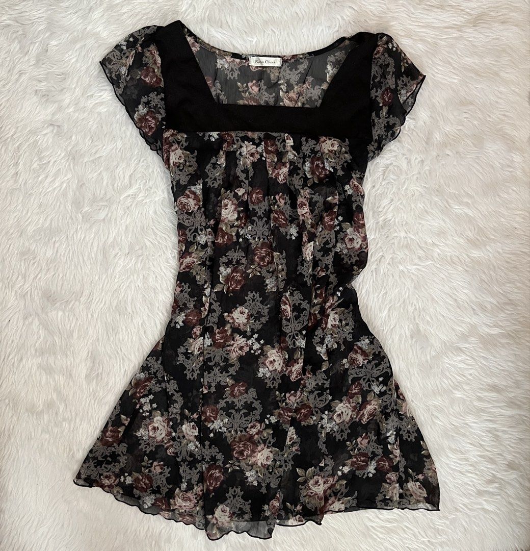 Rosa Cheri Black Floral Chiffon Blouse (Category: Blouses) located in Maasin. Submitted by taraa18 (Listing ID 1469584529, Image 1). Description: - Brand: Rosa Cheri - Material: Lightweight, sheer black chiffon fabric - Design: Vintage-style floral print with roses and intricate grey scrollwork - Neckline: Square neckline with solid black paneling - Sleeves: Short ruffled cap sleeves - Details: Flowy fit with gathered pleats down the front - Cond