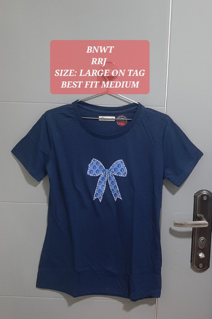 RRJ Blue Bow T-Shirt (Category: Shirts) located in Manila. Submitted by gleeshoppe_lee (Listing ID 1469670579, Image 1). Description: - Brand: RRJ - Color: Dark blue with blue bow graphic on chest - Size: Tagged Large, fits closer to a Medium - Condition: Brand new with original tags attached (Never worn) - Style: Short sleeves and crew neckline.