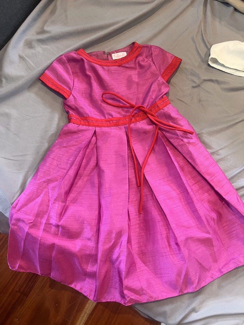 Rustanette Pink Dress Size 5 (Category: Babies & Kids Fashion) located in Manila. Submitted by asecondstory (Listing ID 1469584249, Image 2). Description: - Brand: Rustanette - Size: 5 - Color: Bright pink with red trim details - Features: Attached red waist tie, short sleeves, flared pleated skirt, and back zipper closure - Condition: Clean interior lining with visible brand and size tags.
