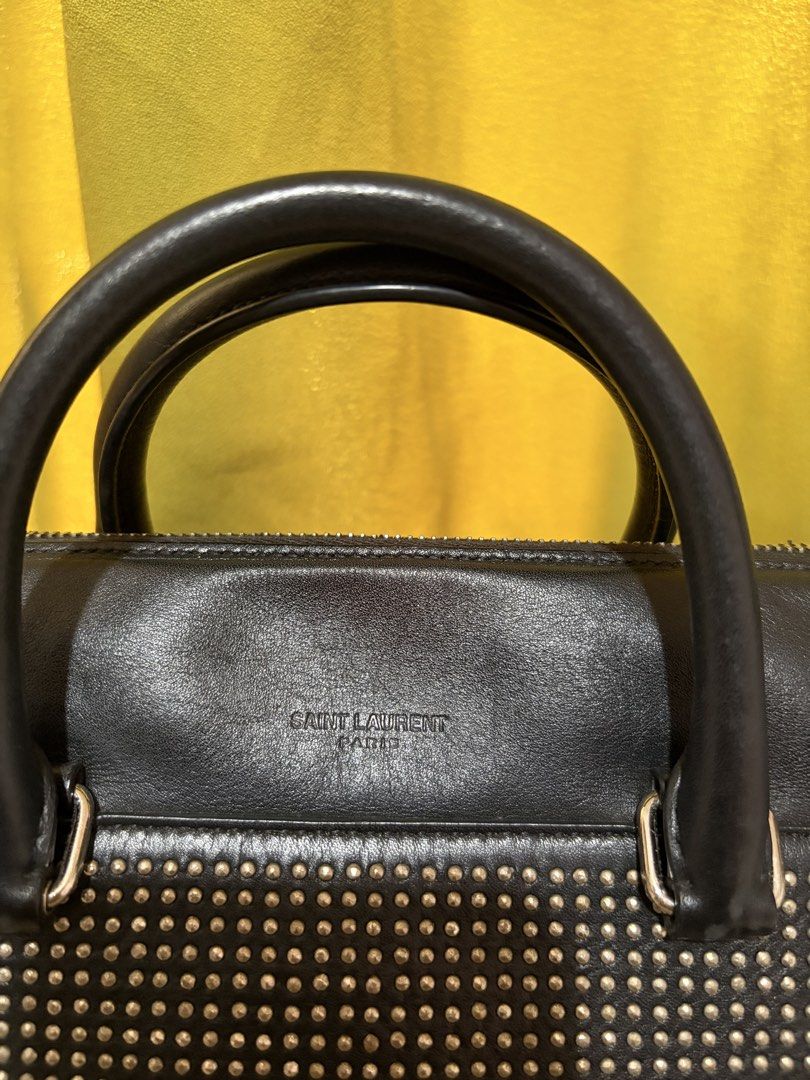 Saint Laurent Classic Duffle Bag (Category: Luxury Bags & Wallets) located in Borongan. Submitted by charmspreloveddd (Listing ID 1469639189, Image 2). Description: Saint Laurent Calfskin Studded Classic Duffle Bag - Dual top handles and adjustable shoulder strap. - Zipper closure across the top. - Interior leather brand tag reads Saint Laurent Paris Made in Italy. - Faded studs but still look good Clean leather body and spotless interior lining.