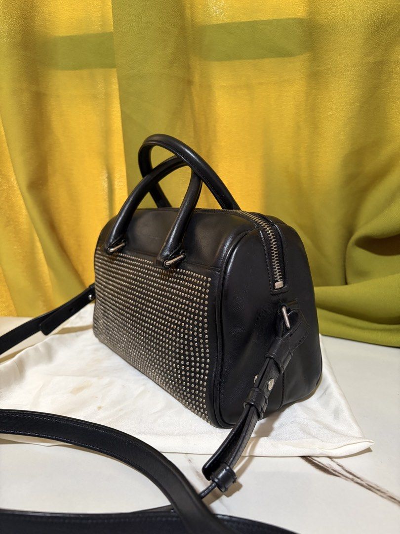 Saint Laurent Classic Duffle Bag (Category: Luxury Bags & Wallets) located in Borongan. Submitted by charmspreloveddd (Listing ID 1469639189, Image 3). Description: Saint Laurent Calfskin Studded Classic Duffle Bag - Dual top handles and adjustable shoulder strap. - Zipper closure across the top. - Interior leather brand tag reads Saint Laurent Paris Made in Italy. - Faded studs but still look good Clean leather body and spotless interior lining.
