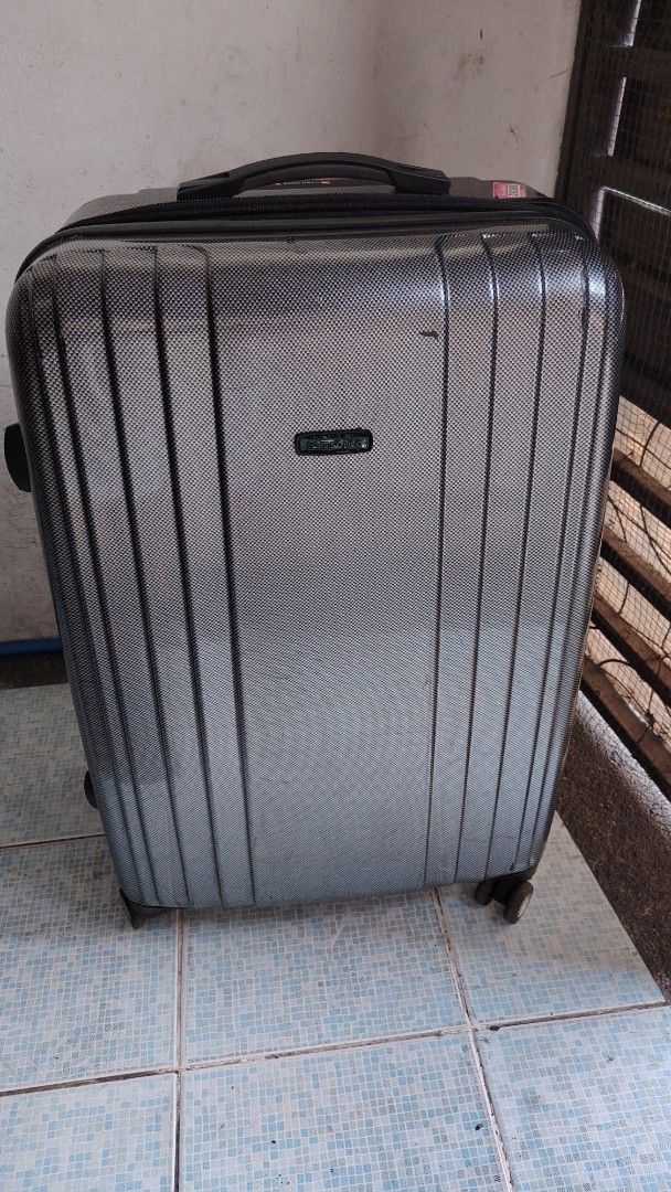 Samsonite Hard Shell Luggage Spinner Suitcase (Category: Luggage) located in Manila. Submitted by purediamond888 (Listing ID 1469657382, Image 3). Description: - Brand: Samsonite - Color/Finish: Dark grey with textured carbon-style finish - Mobility: 4 smooth-rolling spinner wheels - Handles: Equipped with both top and side handles - Security: Built-in side zipper combination lock - Extras: Features cool travel stickers from past adventures - Int