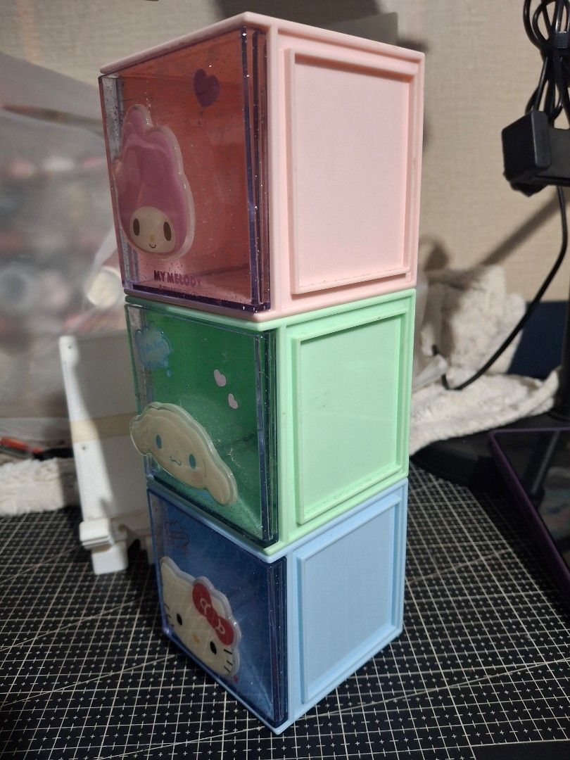 SANRIO Stackable Storage Boxes Set (Category: Storage Boxes & Baskets) located in Rizal. Submitted by emskititay (Listing ID 1469649856, Image 2). Description: Set of three stackable storage cube boxes featuring Sanrio characters. Pink My Melody box, green Cinnamoroll box, and blue Kitty box. Clear glitter sides with character faces on the front drawers. Great for organizing small stationery, trinkets, or desk accessories. Fun way to keep your de