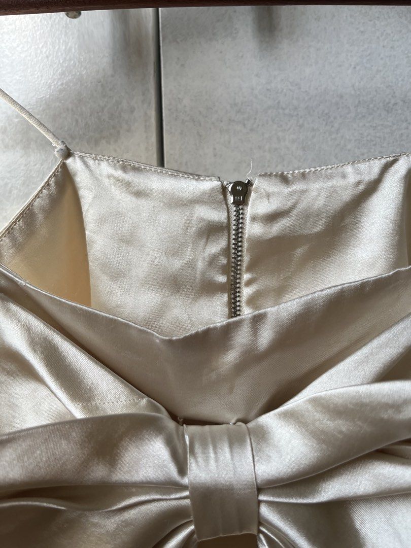 Satin Bow Ribbon Crop Top Cream Spaghetti Strap (Category: Sleeveless) located in Pasig City. Submitted by papainyourhead (Listing ID 1469632664, Image 2). Description: - Color & Material: Cream satin with a smooth, slight sheen - Design: Thin spaghetti straps, big statement bow on the front, and silver back zipper closure - Condition: Worn once or twice, no flaws found - Styling Tip: Looks amazing with high-waisted jeans or a skirt for your next