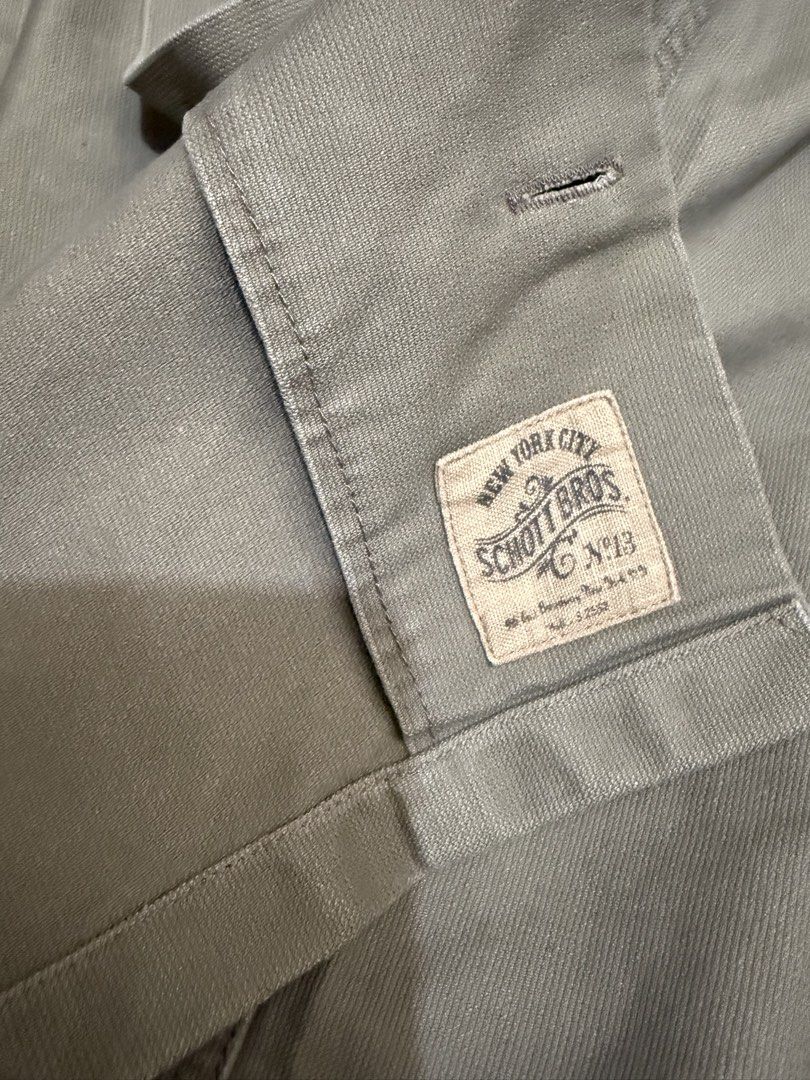Schott Bros New York Khaki Work Jacket (Category: Coats, Jackets and Outerwear) located in Las Pinas. Submitted by nickelcloset (Listing ID 1469601832, Image 2). Description: - Brand: Schott Bros New York - Material: Durable cotton in versatile khaki - Design: Classic collar, button-up front, and dual chest pockets - Details: Subtle sleeve cuff patch and bold Schott Bros New York back lettering - Style: Rugged utility wear, perfect as an everyday