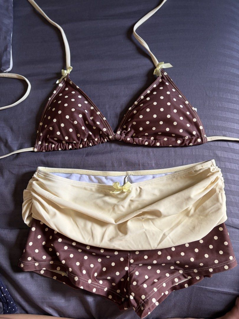 Shein Bikini Set (Category: Bikinis & Swimsuits) located in Malabon City. Submitted by icooooooo (Listing ID 1469619769, Image 1). Description: - Style: Retro brown and cream polka dot bikini set - Top: Triangle design with thin straps and dainty yellow bows - Bottoms: Matching swim shorts with a layered cream skirt overlay - Details: Cute matching bow at the waist - Occasion: Ideal for the beach, pool, or tropical getaways.