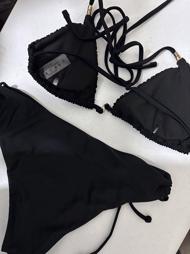 SHEIN Black Ruffle Triangle Bikini Set (Category: Bikinis & Swimsuits) located in Pasig City. Submitted by prelovedbysco (Listing ID 1469592390, Image 2). Description: - Brand: SHEIN Swim - Size: Small (tag attached) - Color: Classic Black - Fabric: Textured crinkle material - Details: Chic gold-tone hardware rings and tube accents - Top: Triangle style with halter ties and removable padding slots - Bottoms: Adjustable side ties for a custom fit 