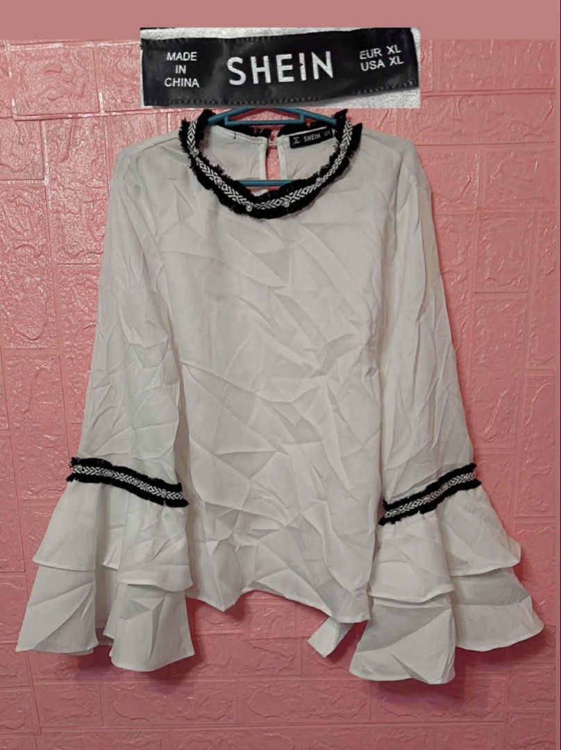 SHEIN White Bell Sleeve Blouse XL (Category: Blouses) located in Pasig City. Submitted by revieconde (Listing ID 1469755612, Image 1). Description: - Brand: SHEIN - Size: EUR XL / USA XL - Color: White with black and white patterned trim - Details: Layered bell sleeves, matching neckline trim, back keyhole with button closure - Material: Lightweight fabric, standard fit - Condition: Excellent addition to your wardrobe.