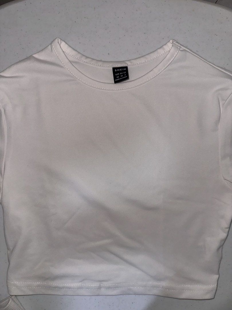 SHEIN White Crop Top XS (Category: Sleeveless) located in Pasig City. Submitted by prelovedbysco (Listing ID 1469693973, Image 2). Description: - Brand: SHEIN - Size: Extra Small (XS) - Color: Classic White - Style: Cropped t-shirt with short sleeves and crew neck - Material: Lightweight and breathable - Fit: Perfect match for high-waisted jeans, skirts, or shorts RFS: decluttering .