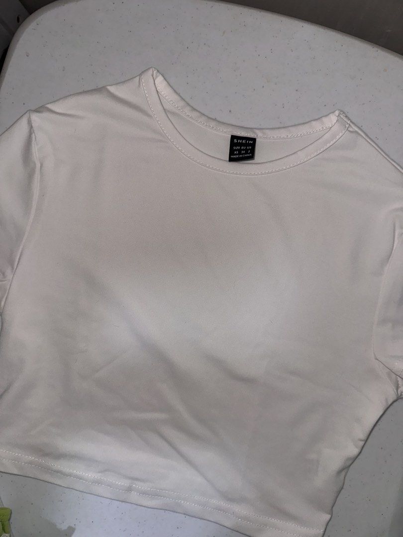 SHEIN White Crop Top XS (Category: Sleeveless) located in Pasig City. Submitted by prelovedbysco (Listing ID 1469693973, Image 1). Description: - Brand: SHEIN - Size: Extra Small (XS) - Color: Classic White - Style: Cropped t-shirt with short sleeves and crew neck - Material: Lightweight and breathable - Fit: Perfect match for high-waisted jeans, skirts, or shorts RFS: decluttering .