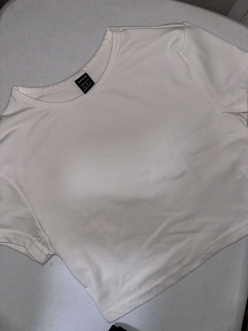 SHEIN White Crop Top XS (Category: Sleeveless) located in Pasig City. Submitted by prelovedbysco (Listing ID 1469693973, Image 3). Description: - Brand: SHEIN - Size: Extra Small (XS) - Color: Classic White - Style: Cropped t-shirt with short sleeves and crew neck - Material: Lightweight and breathable - Fit: Perfect match for high-waisted jeans, skirts, or shorts RFS: decluttering .