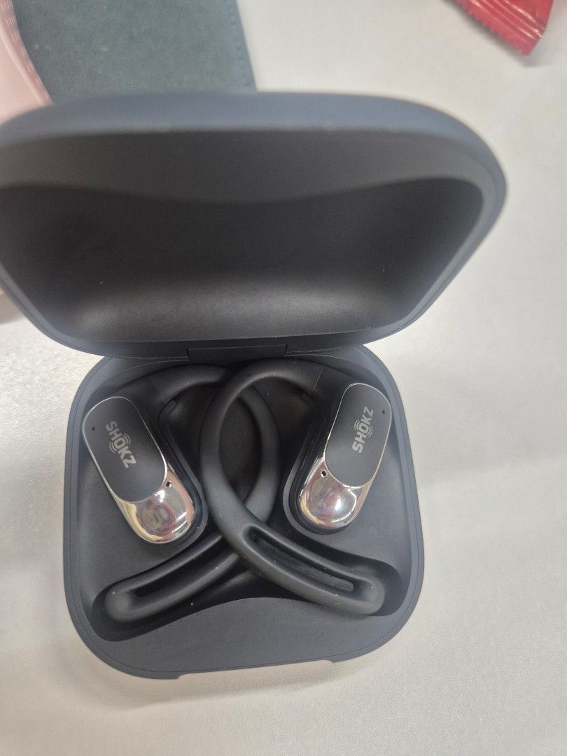 Shokz Openfit Air (Category: Earphones) located in Pasay City. Submitted by gelsanamargaret (Listing ID 1469626383, Image 1). Description: - Brand/Model: Shokz Open Fit Air Wireless Earbuds - Color: Sleek Black and Silver finish - Design: Secure earhook fit, perfect for workouts and running - Condition: Clean inside and out, well-maintained - Performance: Great sound quality with reliable battery charge - Inclusions: Comes with its original charg