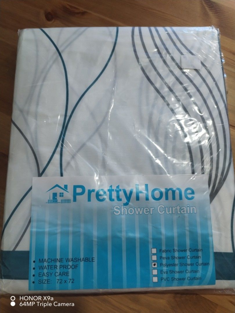 Shower curtain (Category: Bathroom & Kitchen Fixtures) located in Muntinlupa City. Submitted by arciagamaryann68 (Listing ID 1469590752, Image 3). Description: - Brand: PrettyHome - Type: Polyester Shower Curtain - Size: 72 x 72 inches - Color/Design: White with blue abstract wave pattern and teal border - Features: Waterproof, machine washable, and easy care - Inclusions: Comes complete with white curtain rings - Condition: Brand new in original