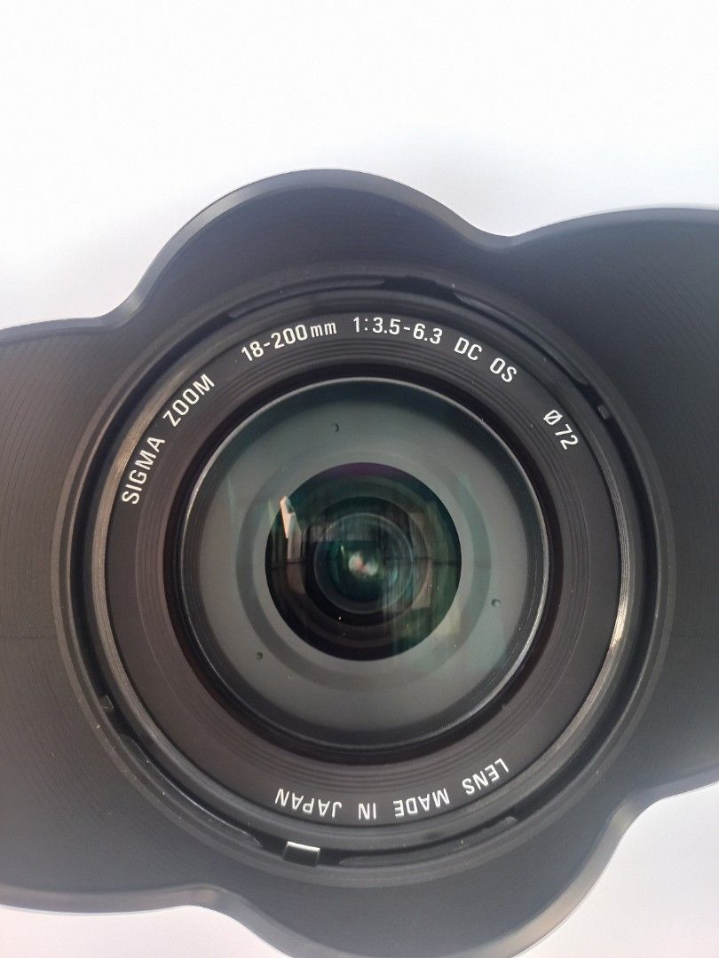 Sigma 18-200 mm Canon mount (Category: Lens & Kits) located in Quezon City. Submitted by plymouth2007 (Listing ID 1469751539, Image 3). Description: - Model: Sigma 18-200mm Zoom Lens with Optical Stabilizer (OS) - Mount: Canon EF mount - Filter Diameter: 72mm - Condition: Clean glass elements inside and out; working AF/MF switch - Inclusions: Flower-shaped lens hood and rear cap - Perfect all-around lens for travel, portraits, and everyday shooti
