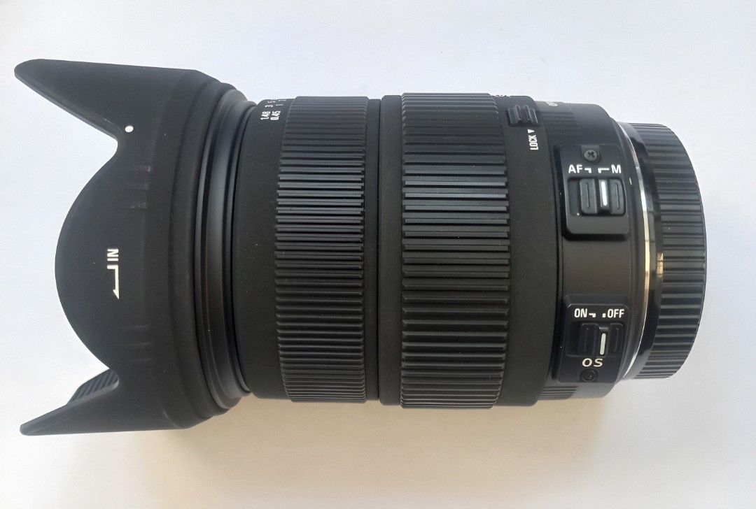 Sigma 18-200 mm Canon mount (Category: Lens & Kits) located in Quezon City. Submitted by plymouth2007 (Listing ID 1469751539, Image 2). Description: - Model: Sigma 18-200mm Zoom Lens with Optical Stabilizer (OS) - Mount: Canon EF mount - Filter Diameter: 72mm - Condition: Clean glass elements inside and out; working AF/MF switch - Inclusions: Flower-shaped lens hood and rear cap - Perfect all-around lens for travel, portraits, and everyday shooti