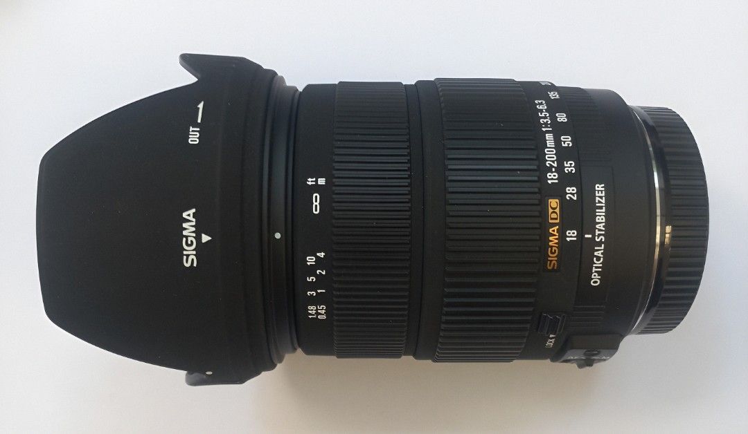 Sigma 18-200 mm Canon mount (Category: Lens & Kits) located in Quezon City. Submitted by plymouth2007 (Listing ID 1469751539, Image 1). Description: - Model: Sigma 18-200mm Zoom Lens with Optical Stabilizer (OS) - Mount: Canon EF mount - Filter Diameter: 72mm - Condition: Clean glass elements inside and out; working AF/MF switch - Inclusions: Flower-shaped lens hood and rear cap - Perfect all-around lens for travel, portraits, and everyday shooti
