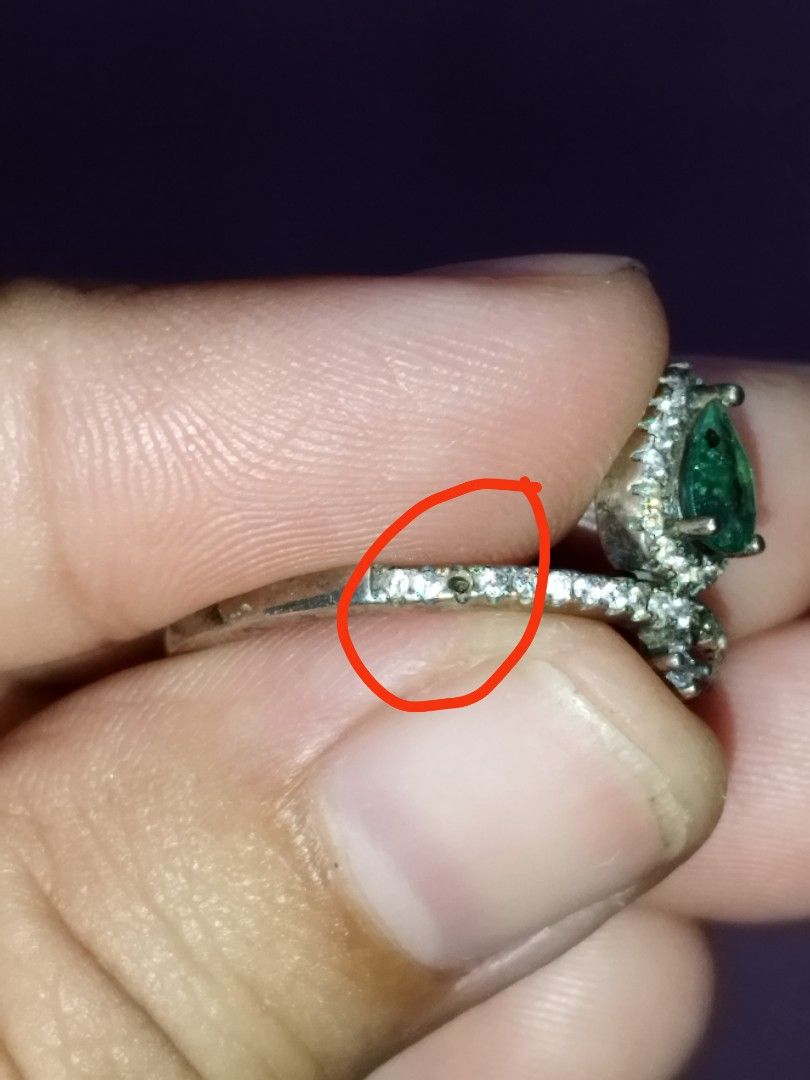 Silver Pear Cut emerald gemstone Ring with Rhinestone Band (Category: Rings) located in Manila. Submitted by Cie28 (Listing ID 1469720376, Image 3). Description: - Silver ring with a striking pear-shaped emerald center stone - Surrounded by a halo of small sparkling rhinestones - Size: Approximately 8 on the sizing stick - Condition Note: Noticeable missing stone on the band (clearly shown in the 3rd photo) - Ready to wear as-is or clean up!.