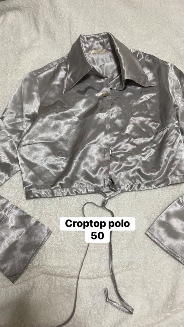 Silver Satin Croptop Polo Shirt (Category: Blouses) located in Manila. Submitted by remotorose29730 (Listing ID 1469644555, Image 1). Description: - Color/Material: Shiny silver satin fabric - Style: Crop top polo with long sleeves and a pointed collar - Closure: Front button near the collar area - Fit: Adjustable drawstring hem for a customized, cinched look - Versatility: Perfect for casual outings or night outs, great with high-waisted jeans o