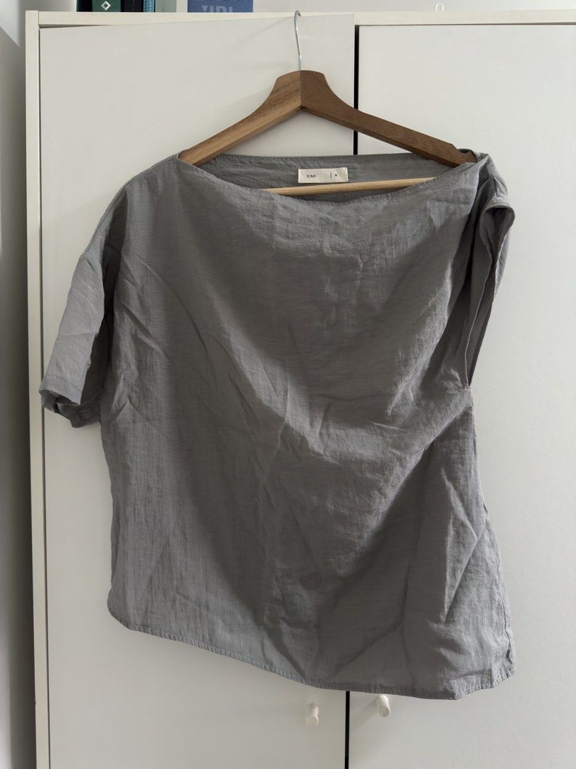 SOMS Grey Asymmetric Blouse Size M (Category: Blouses) located in Marilao. Submitted by declutteringyana (Listing ID 1469580339, Image 1). Description: - Brand: SOMS - Size: M - Color: Grey - Neckline: Asymmetric - Fit: Relaxed through the body - Sleeves: Short sleeves with clean hem stitching - Fabric: Lightweight and textured - Style: Versatile, easy to pair with skirts or pants for daily wear - Condition: Brand new / Excellent (ready to ship!)